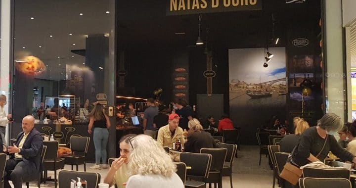 Personas disfrutando de un café con natas en el local de Vialia